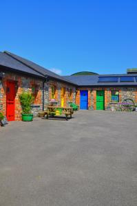 a group of buildings with colorful doors and tables at Slane Farm Hostel, Cottages and Camping in Slane