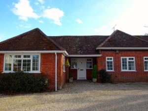 una casa de ladrillo rojo con puerta blanca en The Bothy, en Lyndhurst