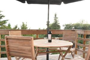 a table with two chairs and a bottle of wine at As casinhas do Moinho in Valença