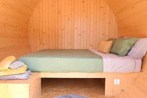 a bed in a sauna with a wooden wall at As casinhas do Moinho in Valença