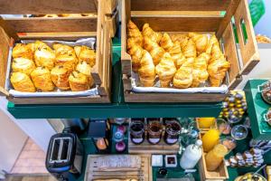 dos cajas de cruasanes y otros pasteles en una panadería en Hotel Ariane Montparnasse by Patrick Hayat, en París