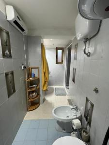 a bathroom with a white toilet and a sink at Ninna House in Villa San Sebastiano