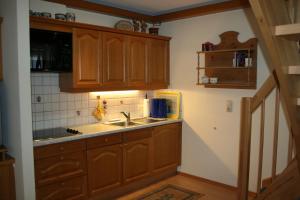 uma cozinha com armários de madeira e um lavatório em Apartment Gredler Maria em Mayrhofen