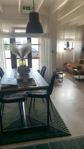 y sala de estar con mesa de comedor y sillas. en Maas Lodge en Maaseik