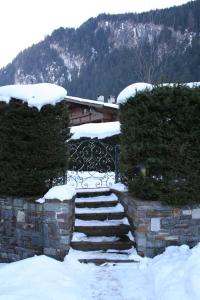pokryte śniegiem schody przed domem w obiekcie Apartment Gredler Maria w Mayrhofen +5 zdjęć