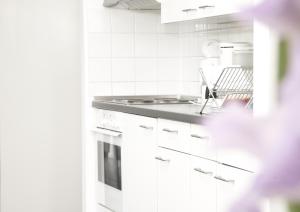 una cucina bianca con lavello e fornello di Karlito Apartmenthaus a Berlino