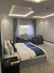 a bedroom with a large bed and a living room at قرين فيو in Abha