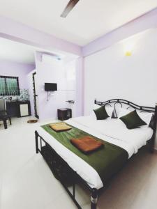 ein Schlafzimmer mit einem großen Bett in einem Zimmer in der Unterkunft Tiger Eye Guest House in Calangute