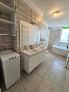 ein Badezimmer mit zwei Waschbecken, einem WC und einer Badewanne in der Unterkunft CENTRAL Apartament Urbana in Arad