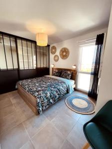ein Schlafzimmer mit einem Bett und einem großen Fenster in der Unterkunft RAVISSANT T2 AVEC VUE MAGIQUE SUR L'ETANG DE THAU in Balaruc-les-Bains
