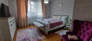 a bedroom with a bed and a purple couch at Infinity Boutique Apartments in Bansko