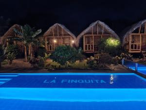 a villa with a pool at night at Hostal La Finquita in Palomino