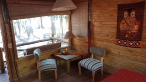 Habitación con mesa, sillas y ventana en Cabaña de Duendes en San Rafael