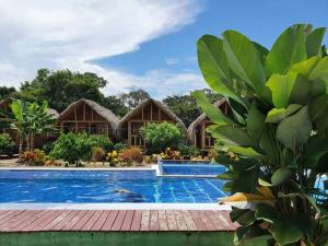 ein Resort mit einem Pool vor einem Gebäude in der Unterkunft Hostal La Finquita in Palomino