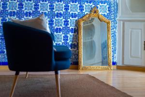 Habitación con silla y espejo. en AltoCanto en Coimbra