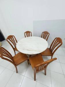 una mesa y sillas blancas con una mesa blanca y 4 sillas en 2-Storey Near Aeon Bukit Indah/ Legoland (6 paxs) en Johor Bahru