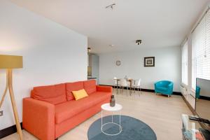 a living room with a orange couch and a table at Farringdon Penthouse Loft by City Living London in London