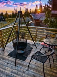 a patio with two chairs and a swing on a deck at Modern New Sports Chalet at Sjusjøen in Ringsaker