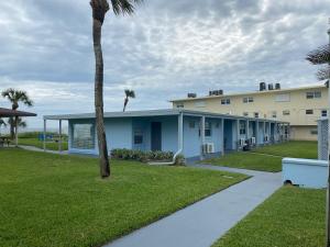 una fila de edificios con palmeras y acera en Sea Aire Oceanfront Inn, en Cocoa Beach