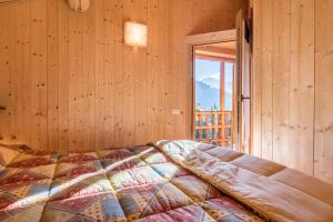 a bedroom with a bed in a room with a window at Baita Dani in San Martino di Castrozza