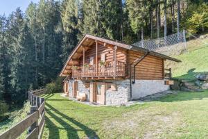 Baita di tronchi con balcone su una collina di Baita Dani a San Martino di Castrozza