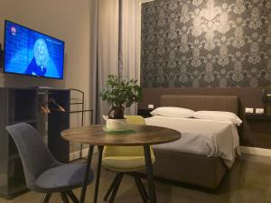 ミラノにあるホテル カリプソのベッドルーム(ベッド1台、テーブル、テレビ付)
