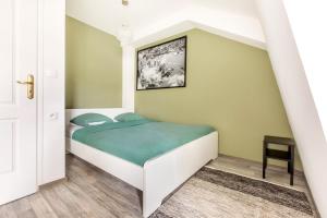um pequeno quarto com uma cama com um cobertor verde em Le Brooklyn em Liévin