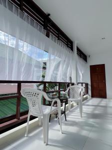 卡塔海灘的住宿－The 4 Blocks at Kata noi，阳台配有2把白色椅子和桌子