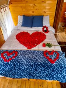 Una cama con rosas rojas y corazones. en Dante Glamping, en Guatavita