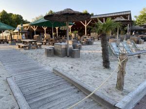 a beach with chairs and umbrellas and tables at Ferienhaus Ella am See in Aurich