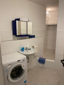 a bathroom with a washing machine and a sink at Hüls Central Apartment in Marl