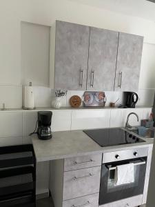 a kitchen with white cabinets and a counter top at Hüls Central Apartment in Marl