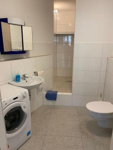 a bathroom with a washing machine and a toilet at Hüls Central Apartment in Marl