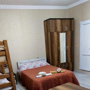 1 dormitorio con 1 cama y armario de madera en The White House, en Kazbegi