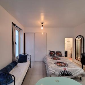 ein Wohnzimmer mit 2 Betten und einem Sofa in der Unterkunft Hollyday Studio Paris Centre Montmarte Sacré-coeur Opera Louvre in Paris