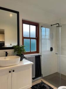 a bathroom with a sink and a glass shower at Lux apartment Plett in Plettenberg Bay