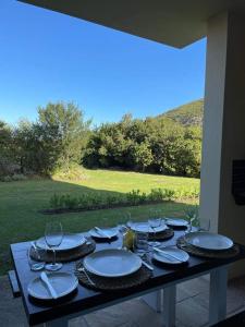 un tavolo con piatti e bicchieri da vino sopra di Lux apartment Plett a Plettenberg Bay