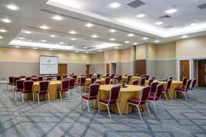 uma sala de conferências com mesas e cadeiras e um ecrã em The Telford Hotel, Spa & Golf Resort em Telford