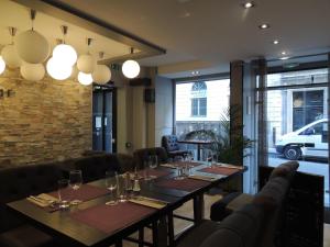 un comedor con una mesa larga con copas de vino en Hôtel Eden Opéra, en París