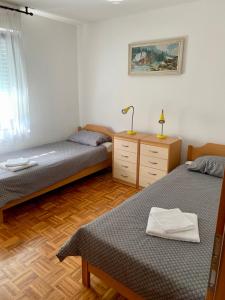 a bedroom with two beds and a desk with a lamp at APARTMA PANORAMA in Kobarid