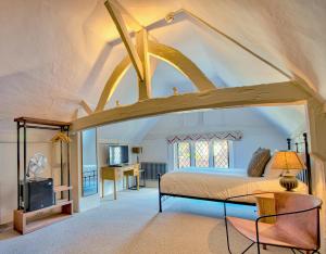an attic bedroom with a bed and a desk at The Woolpack Inn in Coggeshall +27 photos