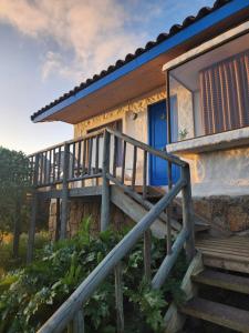 a house with a blue door and stairs at Cabañas Aloha-ki in El Quisco
