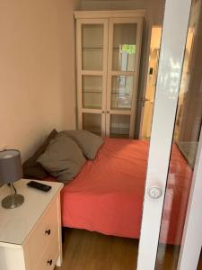 a small bedroom with a red bed and a desk at Suite con Entrada Independiente cerca a IFEMA y Aeropuerto in Madrid