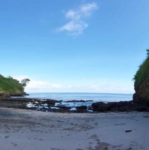 une plage avec des rochers et l'océan par beau temps dans l'établissement OCEAN SURF, à Mompiche