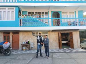 two people standing in front of a house at Hotel PineWood Tawang in Tawang