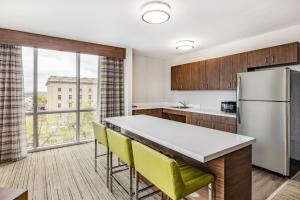 a kitchen with a refrigerator and yellow chairs at Holiday Inn Express & Suites - Lincoln Downtown , an IHG Hotel in Lincoln