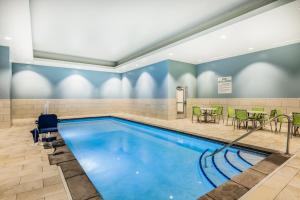 a swimming pool with tables and chairs in a room at Holiday Inn Express & Suites - Lincoln Downtown , an IHG Hotel in Lincoln