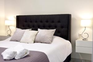 a bedroom with a large bed with white sheets and pillows at Apparlia Athens Luxury Apartment near Acropolis in Athens