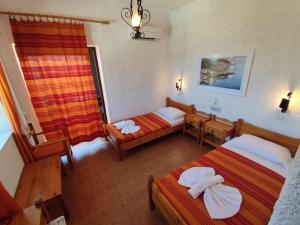 a hotel room with two beds and a window at Hotel Tsagarakis Beach in Amoudara Herakliou