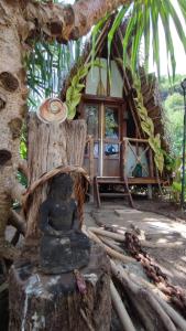 ファールにあるTe Fitii Garden & Beachの家の前の切り株に座る像